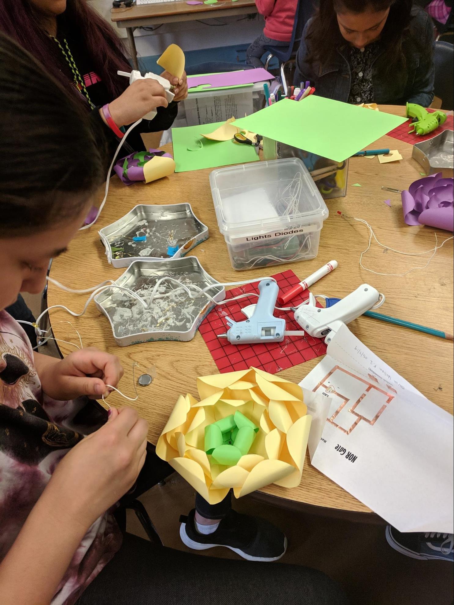 A group of girls around a table working on a project during Tech Chicas