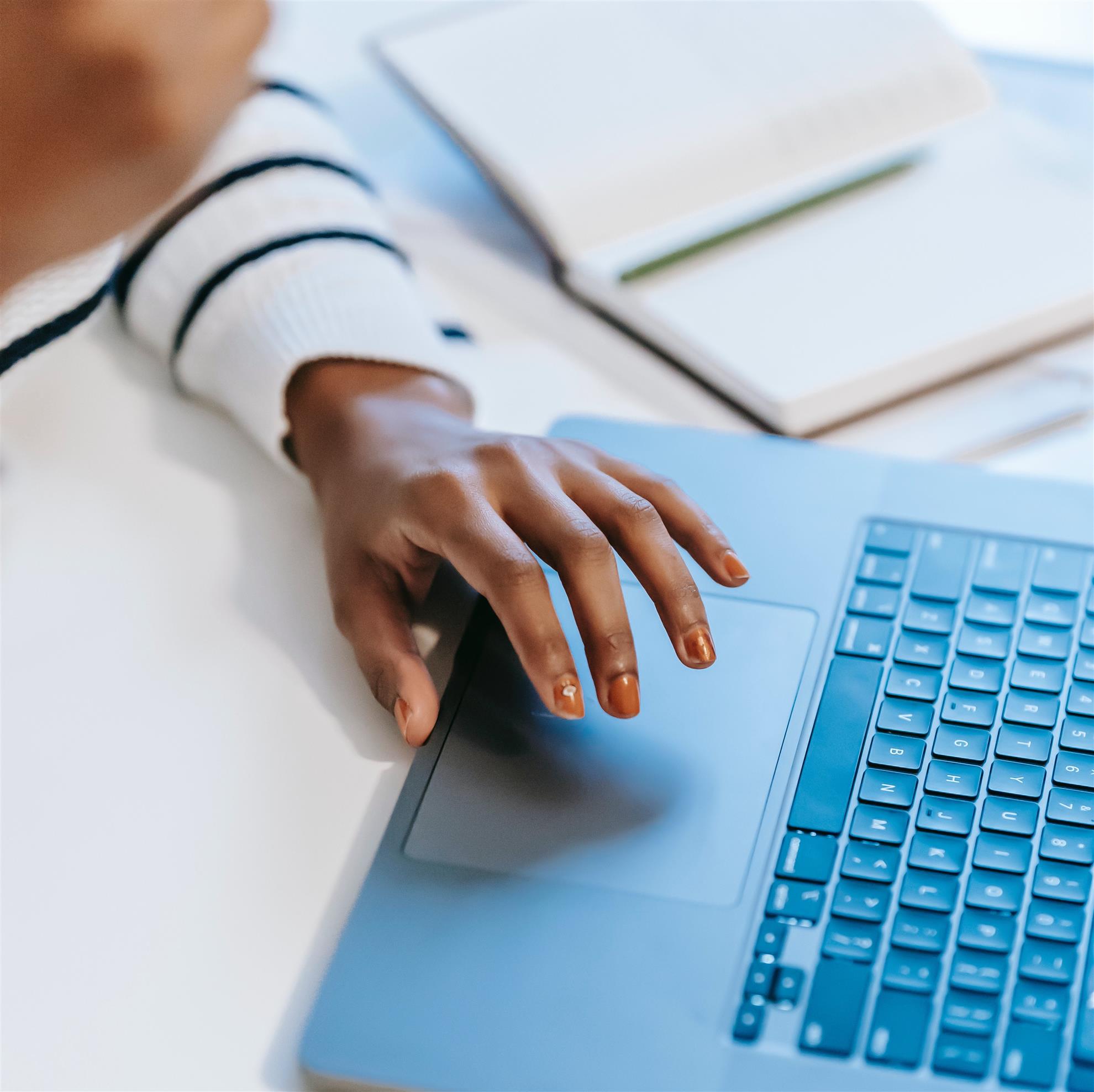 person completing online PD, shown with notebook and computer