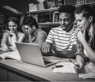 Stock photo of diverse teens around a laptop